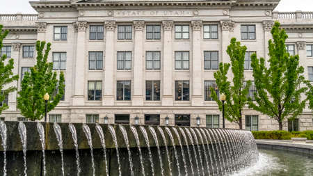 Panorama frame Water pool fountain against Utah State Capital building dome and pediment. Scenic...