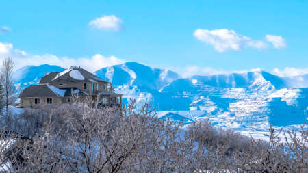 Panorama crop Magnificent Wasatch Mountains in winter with lovely homes and abundant trees....