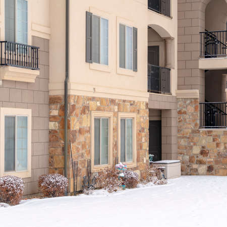 Square Residential apartment building facade with snow covered yard in winterの写真素材
