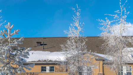 Panorama Exterior of church with lovely frosted trees on the sunlit snowy yard in winter. Blue sky and puffy clouds can be seen at teh bakcground of the religious building.の写真素材