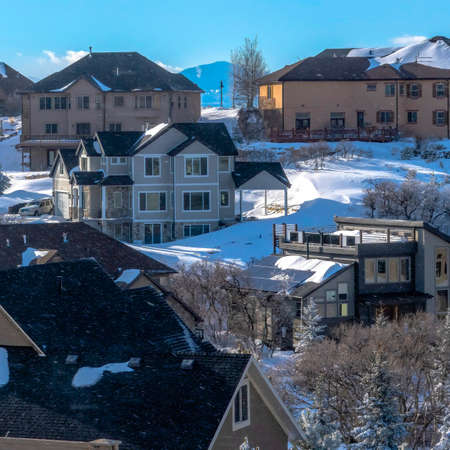 Square crop Pristine Wasatch Mountain landscape with houses on sweeping snowy terrain. Towering peaks and blue sky can be seen in the background.の写真素材