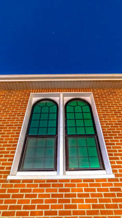 Vertical crop Sliding arched glas windows of a church in provo Utah against brick wallの写真素材