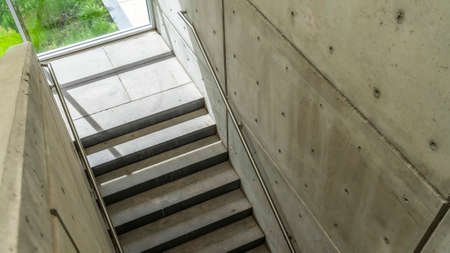 Panorama frame Looking down on staircase with metal handrails inside of commercial building. A...