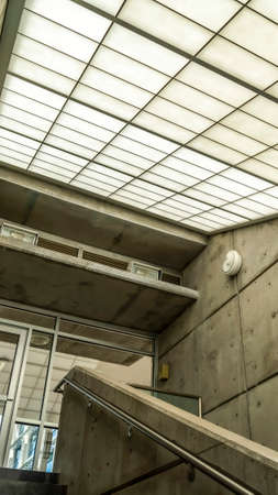 Vertical Indoor staircase of commercial building that leads to the balcony glass door