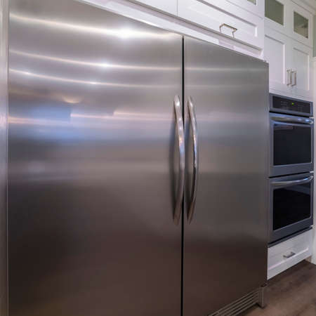 Square frame Large double door American metal finish fridge in a modern fitted kitchen with appliancesの写真素材