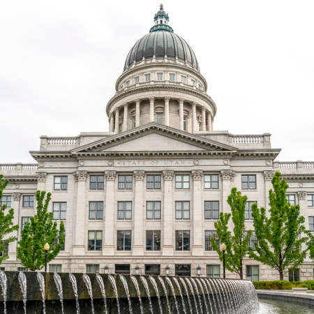 Square Water pool fountain against Utah State Capital building dome and pediment. Scenic exterior view of the famous building in Salt lake City on a cloudy day.の写真素材