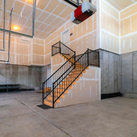 Square frame Empty open plan basement in a modern house or building with steps leading down from aboveの写真素材