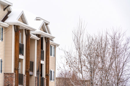 Snowy roof and small balconies viewed at the exterior of a residential buildingの写真素材