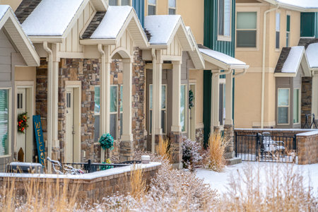 Apartments on a winter setting with gabled entrances porches and snowy yardsの写真素材