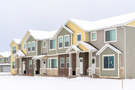 Two storey homes with white doors at front entrances with snowy roofs in winterの写真素材