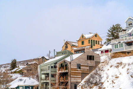 Residential landscape of homes built on mountain community with snowy slopesの写真素材