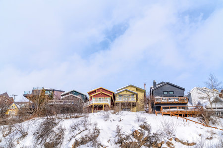 Rocky mountain terrain with homes built on the slopes with snow in winter