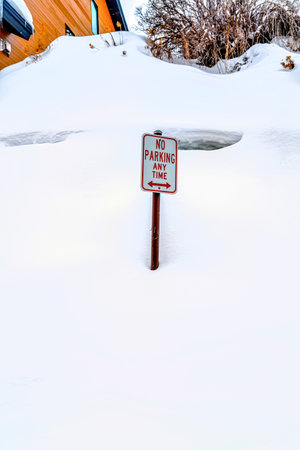 No Parking sign on a neighborhood hill with white snow on a frosty winter dayの写真素材