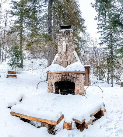 Outdoor stone fireplace in a beautiful landscape of snowy mountain in winterの写真素材