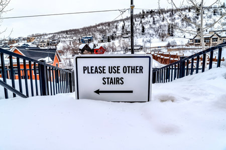 Please Use Other Stairs sign on an impassable stairway in the snowy neighborhoodの写真素材