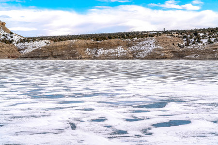 Strawberry Reservoir with a vast sheet of snow covered frozen water in winterの写真素材