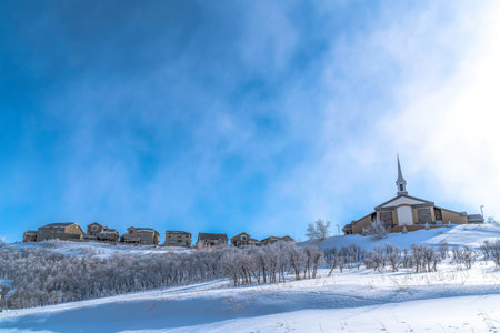 Church and homes on a snowy neighborhood landscape against scenic skyscapeの写真素材