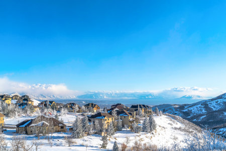 Panorama of snowy mountain town and valley on a scenic sunny winter settingの写真素材