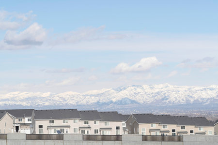 Houses against snowy mountain and scenic skyscape on a neighborhood landscape