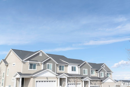 Front view of townhouses against blue sky on a suburban neighborhood landscapeの写真素材