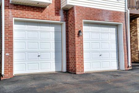 White panelled garage doors of townhouses in the neighborhood on a sunny dayの写真素材