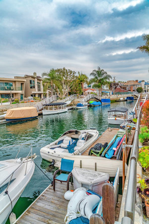 Leisure boats on public canal lined with elegant houses in Long Beach Californiaの写真素材