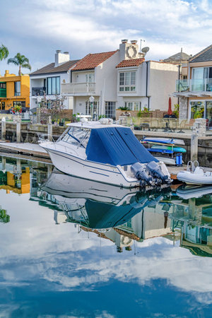 Yacht and dock on water with refletion of overcast sky at a coastal neighborhoodの写真素材