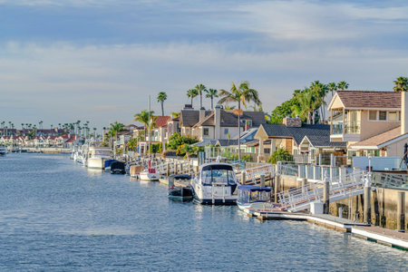 Waterfront homes with private docks and yachts overlooking the sea at sunsetの写真素材