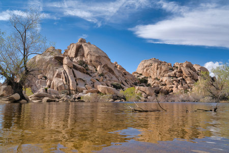 Big horn dam reservoir at Joshua Tree National Park against huge rocks and skyの写真素材