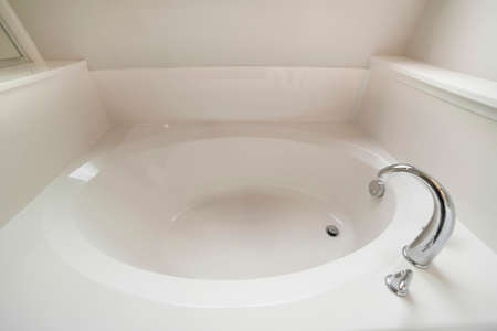 Interior of a bathroom with bathtub, drainage and faucet