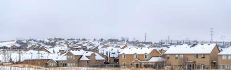 Big and beautiful houses with white roofs with the white cloudy skyの写真素材