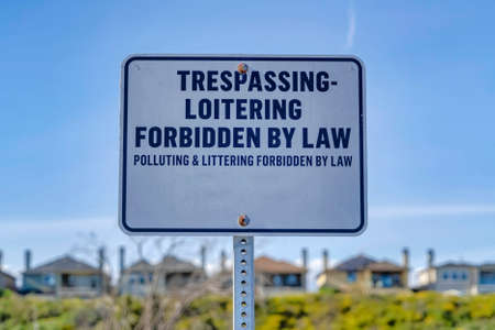 Trespassing Loitering Forbidden By Law sign against blue sky on a sunny dayの写真素材