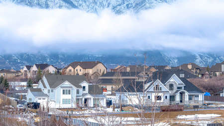 Pano Utah Valley community with towering Wasatch Mountain and dense clouds backgroundの写真素材