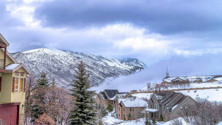 Pano Picturesque view of winter houses with overcast sky background on a sunny day