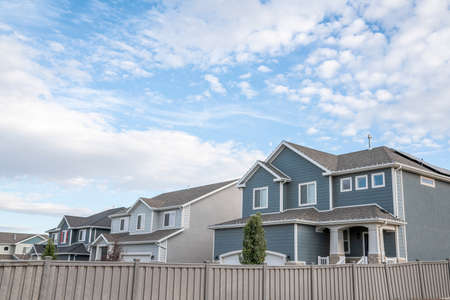 Two-storey houses in a residential area against a beautiful sky and clouds backgroundの写真素材