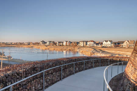 Curved pathway with metal barriers in the middle of gabion retaining walls