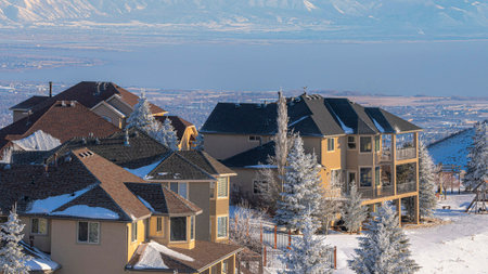 Pano The sun is casting its light on two huge houses without people outside.