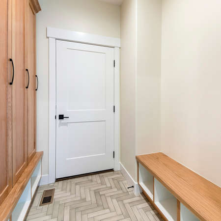Square frame Mudroom interior with herringbone tile pattern flooring and wooden cabinetの写真素材