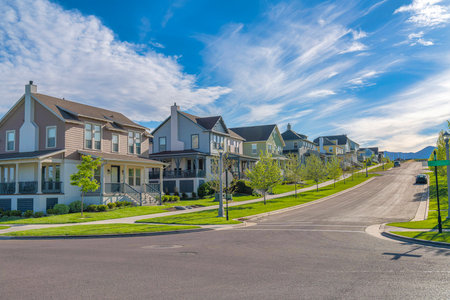Row of large two-storey houses near the paved uphill road at Daybreak, Utahの写真素材