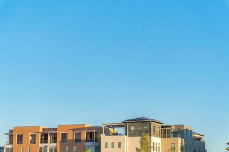 Exterior of the top floors of two complex apartment buildings with balconiesの写真素材