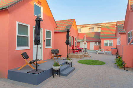 Small cabins at Oceanside, California with lounge chairs and umbrellas at the doorstep