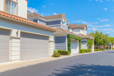 Driveways of two storey houses at Ladera Ranch in California. There are houses with sectional garage doors with different colors and structures.の写真素材
