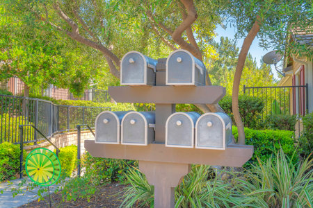 Mailboxes rack at Ladera Ranch in Southern California. Mailboxes near the plants and trees outside the fenced residences at the back with handrails on the left.の写真素材