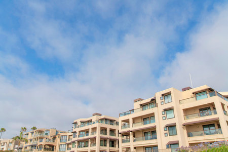 Low rise residential buildings at La Jolla in California. Buildings exterior with glass railings and canopies on the windows and terrace against the sky background.の写真素材