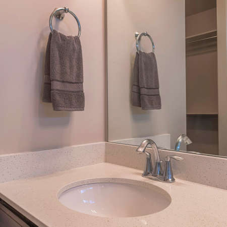 Square Sink with granite countertop and towel on a ring holderの写真素材