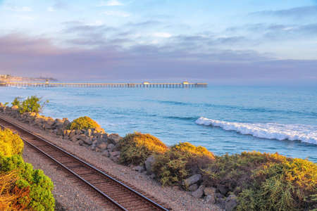 Railway at San Clemente in California with a view of the ocean waves and pier against the skyの写真素材
