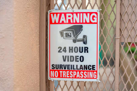 Surveillance camera signage on a metal mesh wire railings at San Francisco, Californiaの写真素材