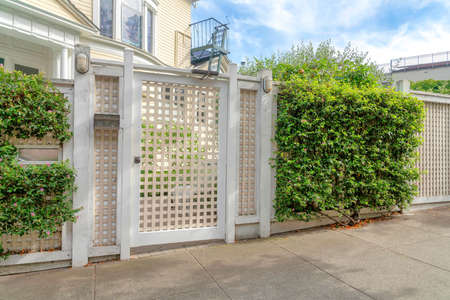 Beige grid single gate door with shrubs on the fence at San Francisco, California