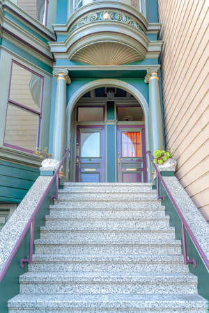Victorian style townhouse entrance exterior with concrete stairs and metal handrail at San Franciscoの写真素材