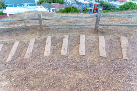 Wood planks strips on the dirt trail near the wooden fence at San Francisco, Californiaの写真素材